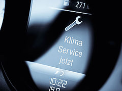 Das Bild zeigt den Bildschirm des Boardcomputers im Auto mit der Warnung "Klima Service fällig"